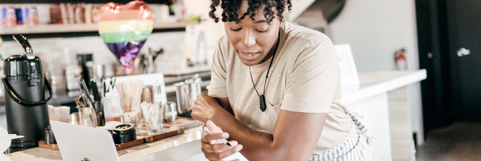 Woman working at table with laptop and cell phone